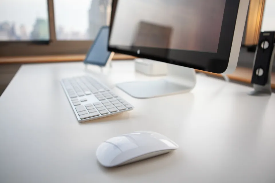 A clean desk with a desktop computer, keyboard and mouse